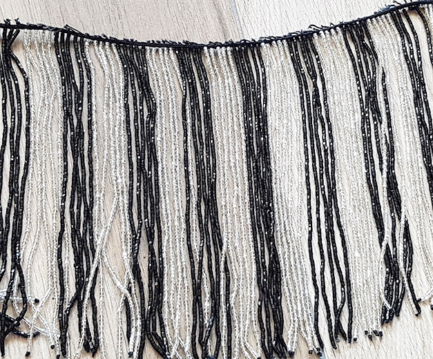 Perlenkette mit schwarz/weißen Schnüren und vielen Perlen

 60cm lang, Stränge 20cm lang